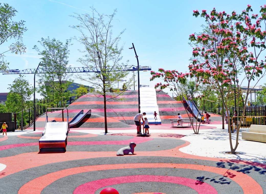 Wide shot of Glòries Park with children playing