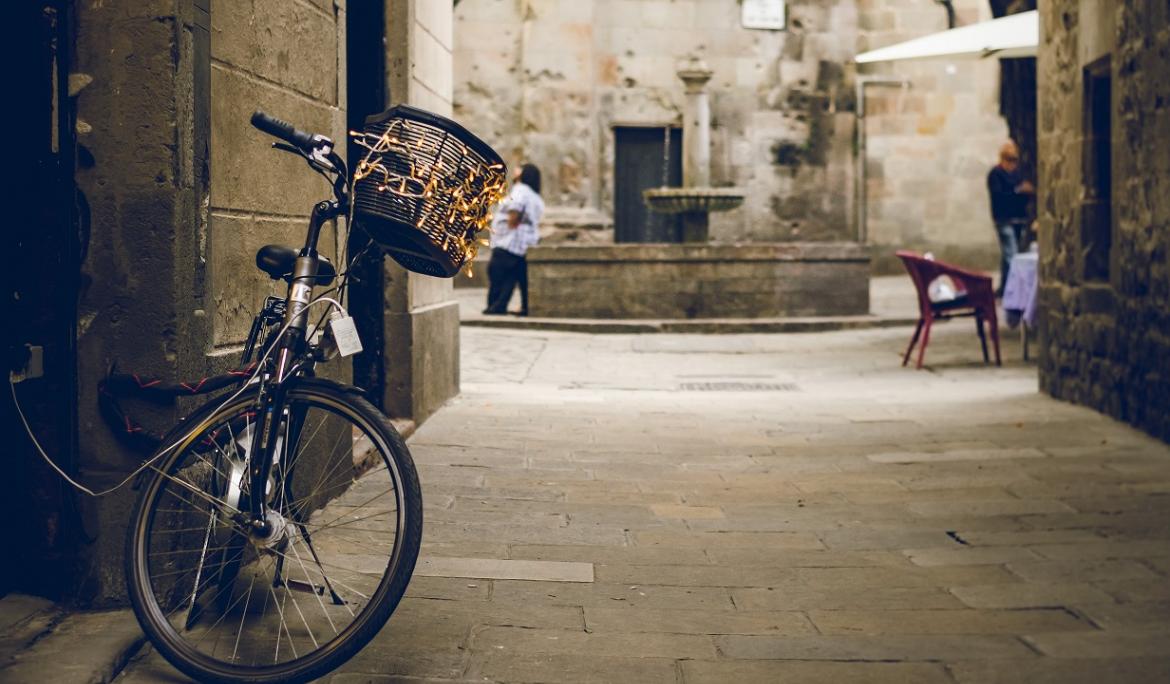 Primer plànol d'una bicicleta amb la plaça de Sant Felip Neri al fons