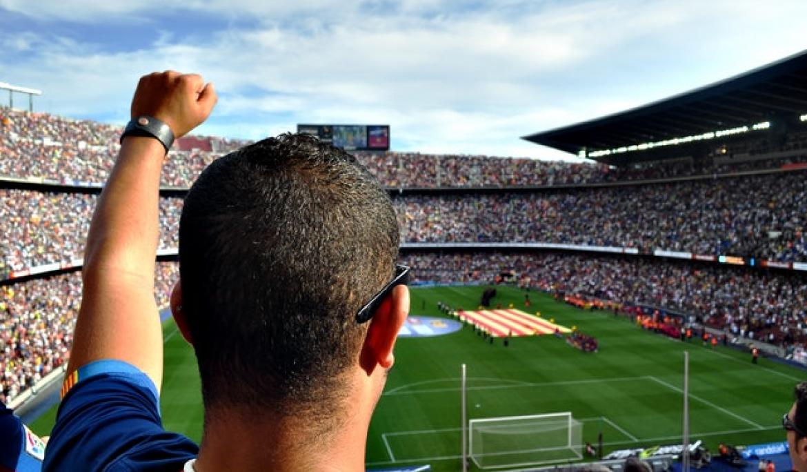 Aficionat gaudint d’un partit de futbol al Camp Nou