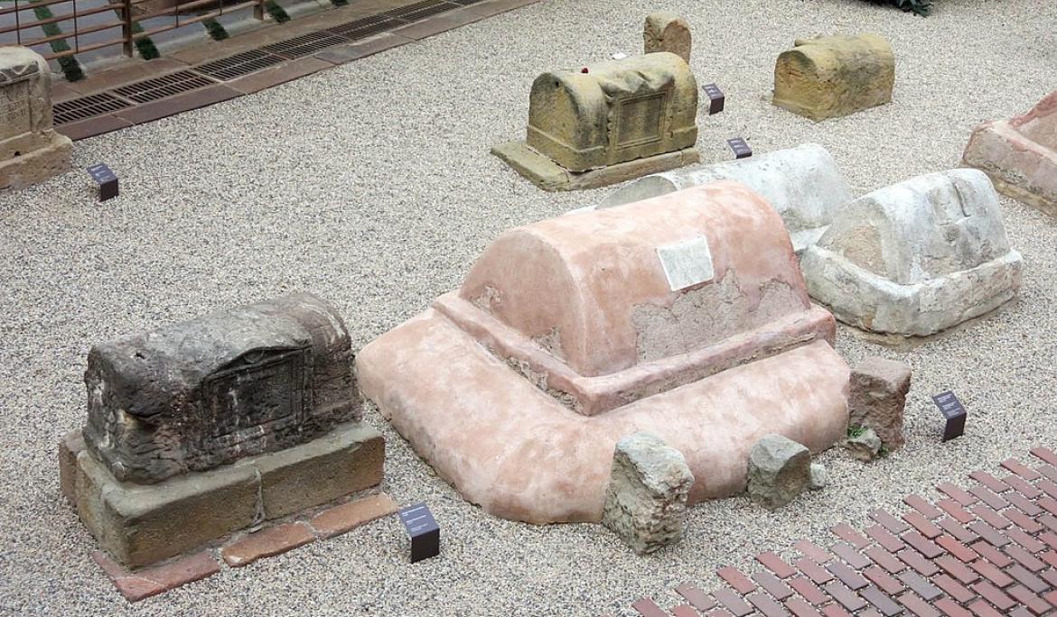 L'any 1954, de casualitat, es va descobrir una part de la necròpolis d'extramurs de Barcino a la plaça de la Vila de Madrid / https://commons.wikimedia.org/wiki/File:76_Necr%C3%B2polis_romana,_pl._Vila_de_Madrid.JPG