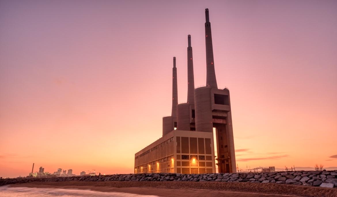 Sunset behind the Tres Xemeneies building, one of Barcelona’s major technological and audiovisual hubs, with the sea in the background.