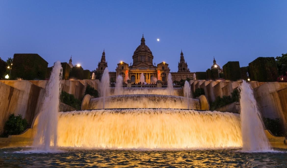 A ground level view of the Magic Fountain of Montjuïc at sunset.