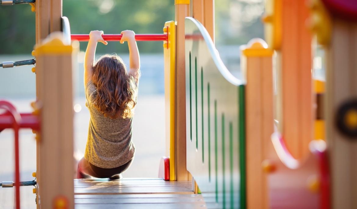 Image of a child playing in a colourful wooden play area in a Barcelona playground.