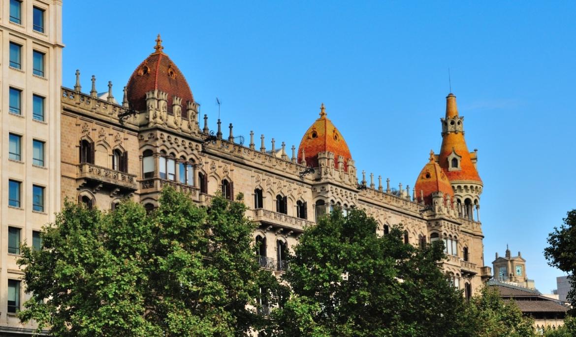 A view of one of the most striking façades on Passeig de Gracia in the late afternoon, set against a clear blue sky.