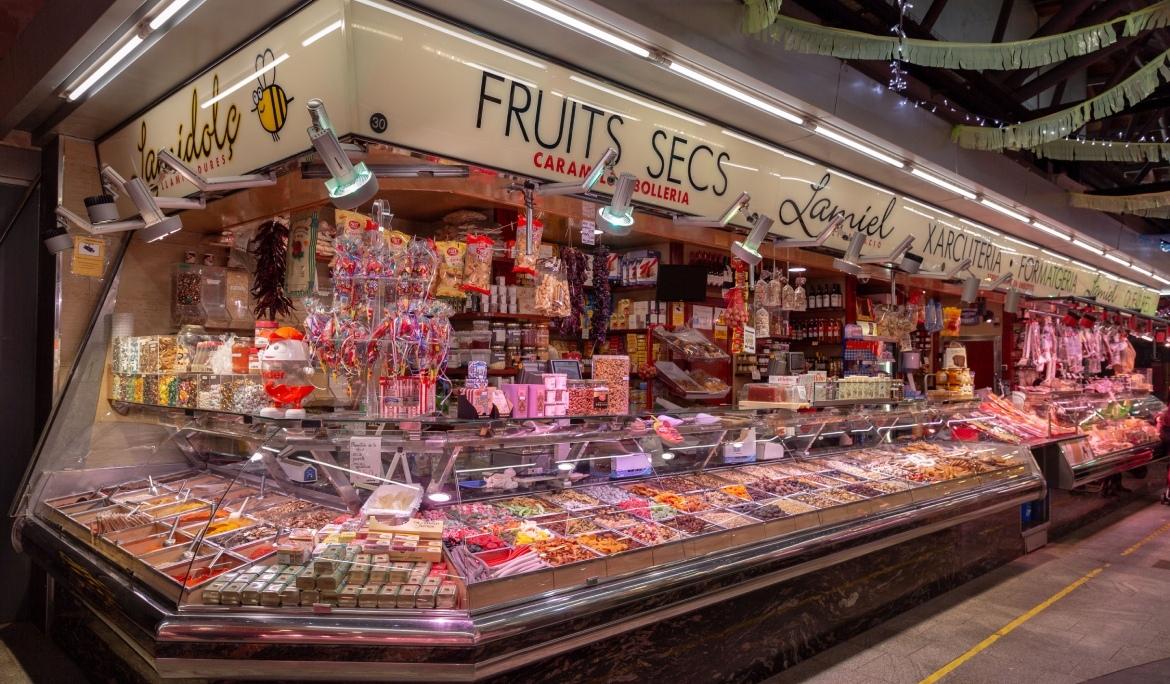 Paradeta de llaminadures i fruits secs a l'interior d’un mercat de Barcelona.