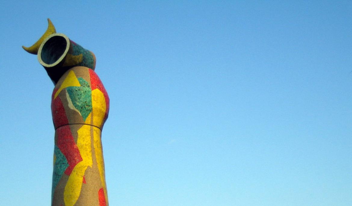 A tall, colorful sculpture set against a bright blue sky