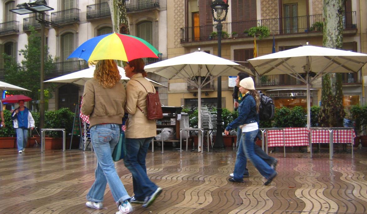 Two couples walking along Les Rambles on a rainy dy