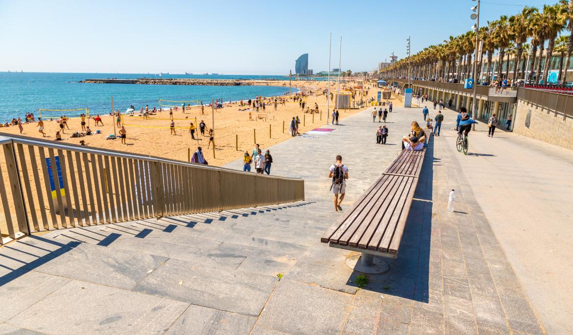 Entrada a la Barceloneta con el contraste de la zona asfaltada con la arena de la playa.