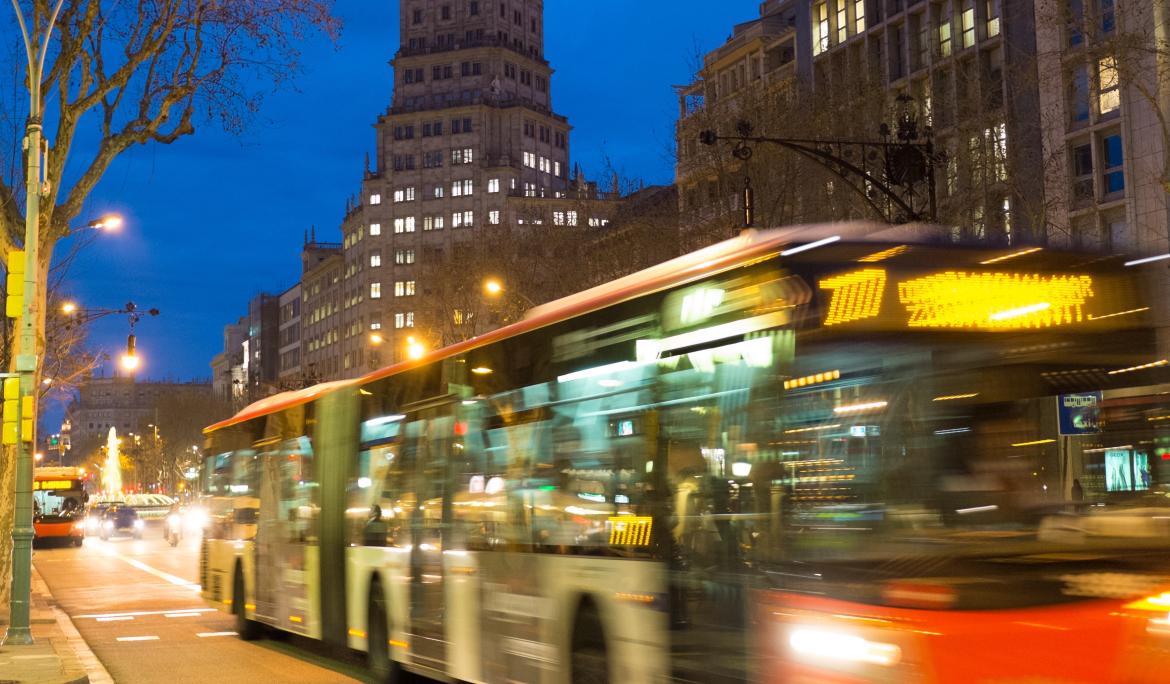 Bus en movimiento por una calle de Barcelona de noche.