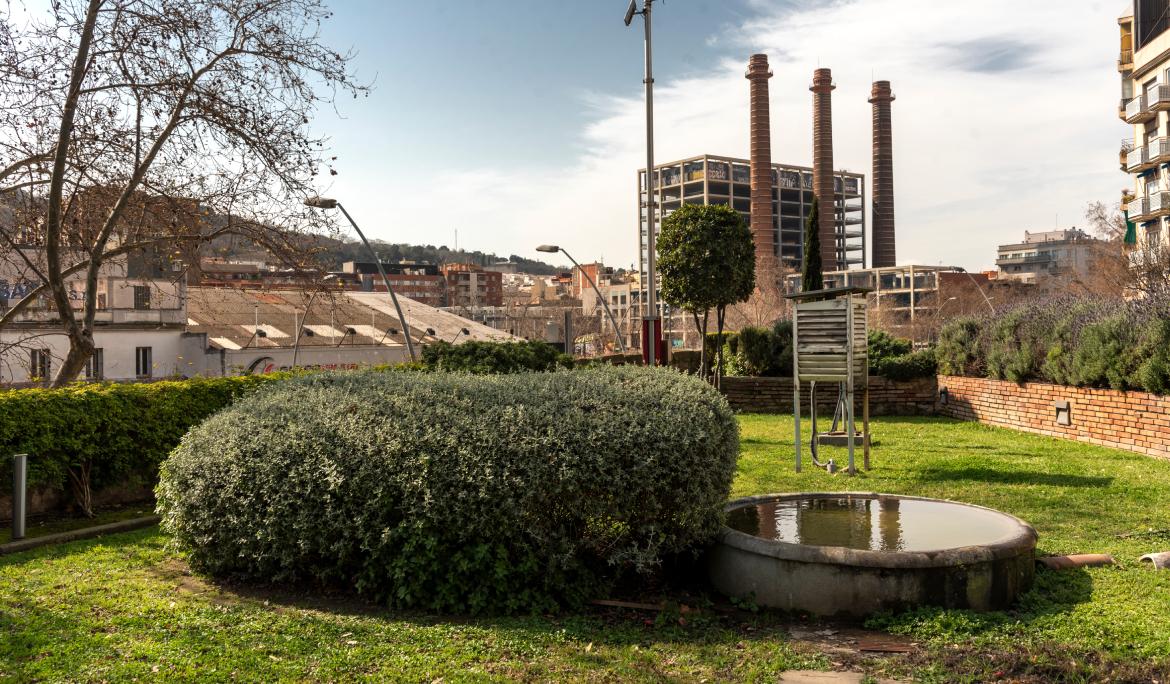 Image of the more urban side of the city with the garden in the foreground and the three chimneys in the background.