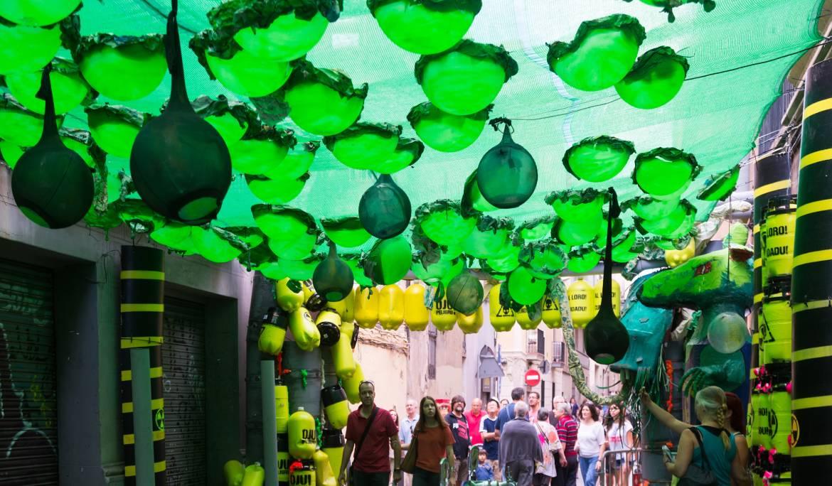 Carrer decorat amb sostres verds i granotes per la festa major de Gràcia