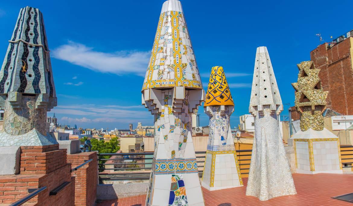 Imatge de les xemeneies modernistes del Palau Güell. son petites columnes de colors fetes amb trencadís de diferents materials.