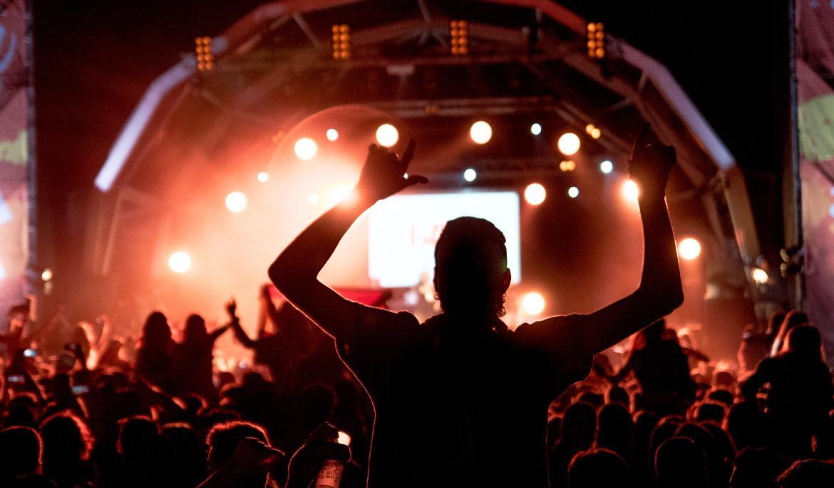 Concert a la platja de Bogatell de nit amb gent gaudint de la música.