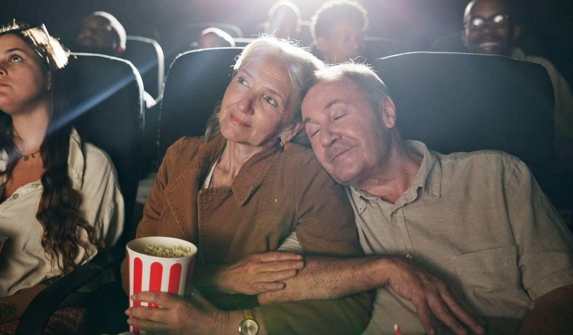 Dos avis abraçats al cine.