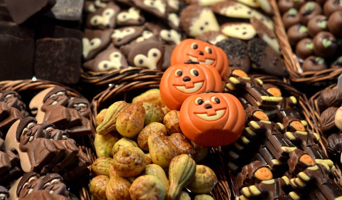 Image showing traditional panellets pastries alongside Halloween-themed sweets and chocolates.