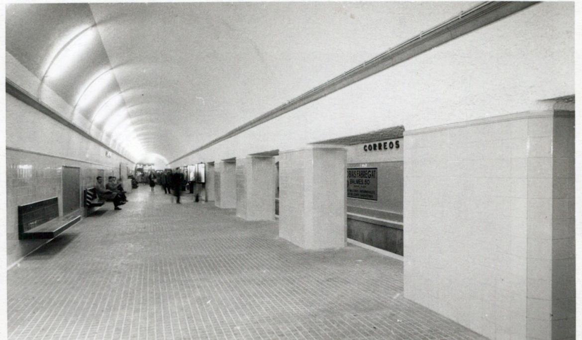 Photograph showing the dim, abandoned platform along the active metro track inside the tunnel.