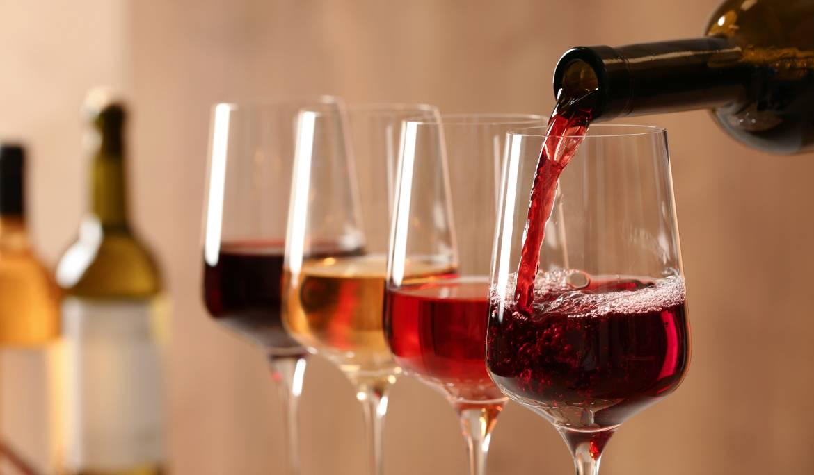 Image showing a wine tasting setup with glasses of white and red wine alongside fresh grapes.