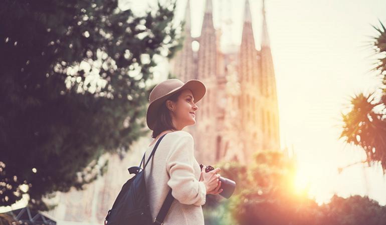 Chica con cámara de fotos y la Sagrada Familia de fondo