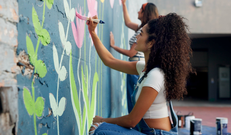 Imatge de dues dones pintant un mural feminista col·laboratiu pel 8M a Barcelona