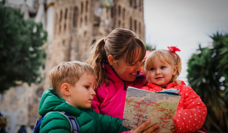 A mother with two small children visiting Barcelona with the Sagrada Família in the background